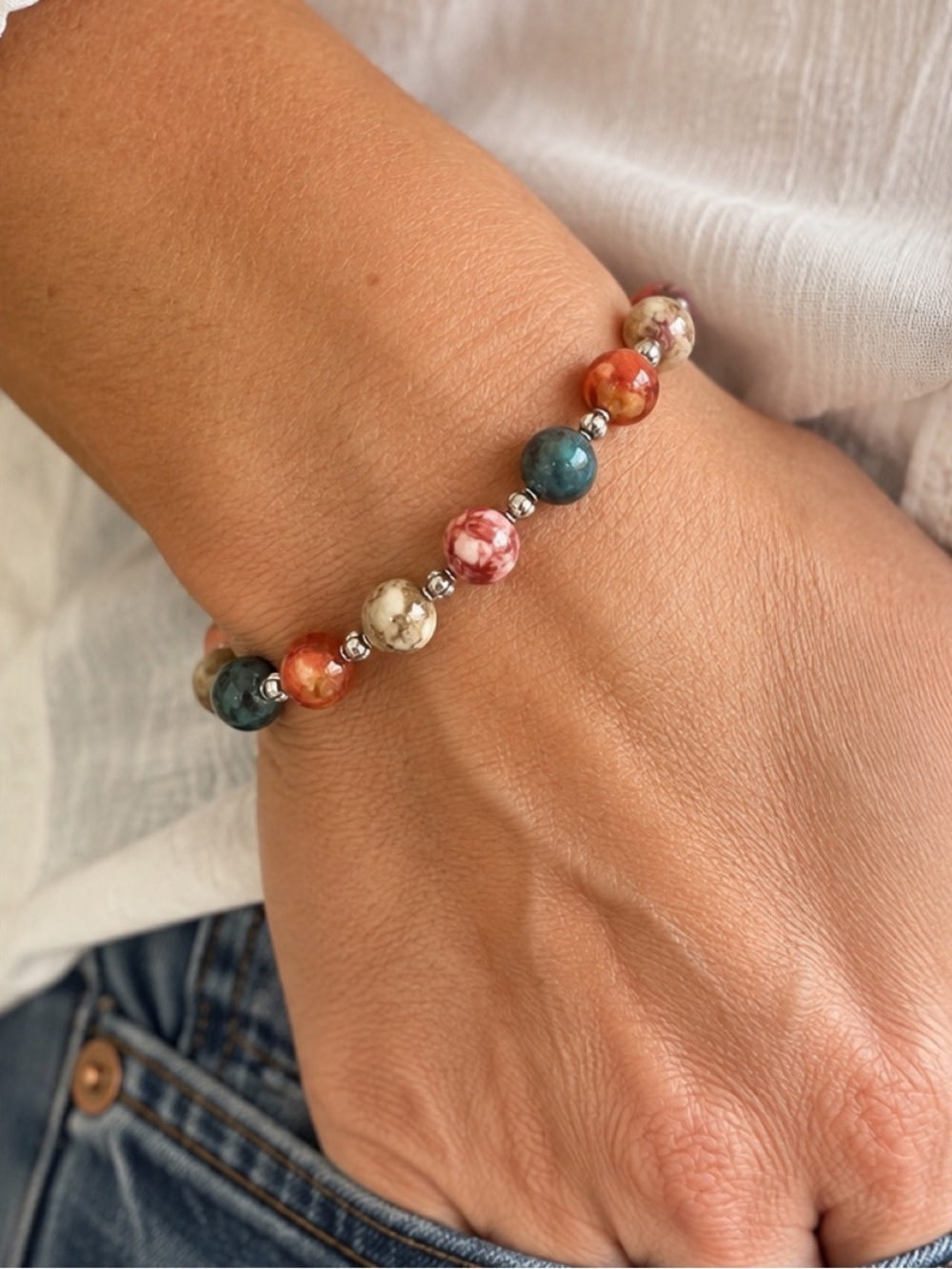 Multi Colored beaded stretch bracelet in the colors green, red, cream, orange